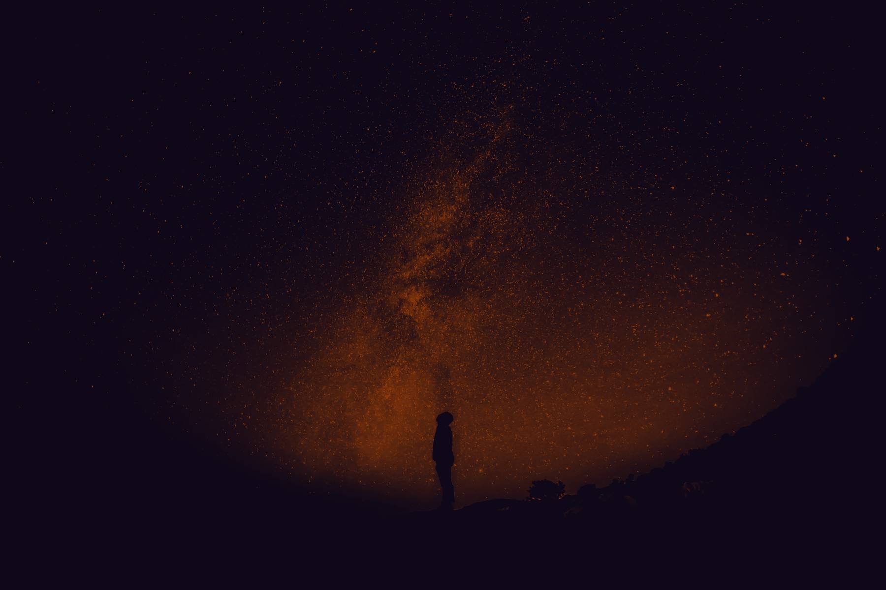 A lone figure standing under the Milky Way
