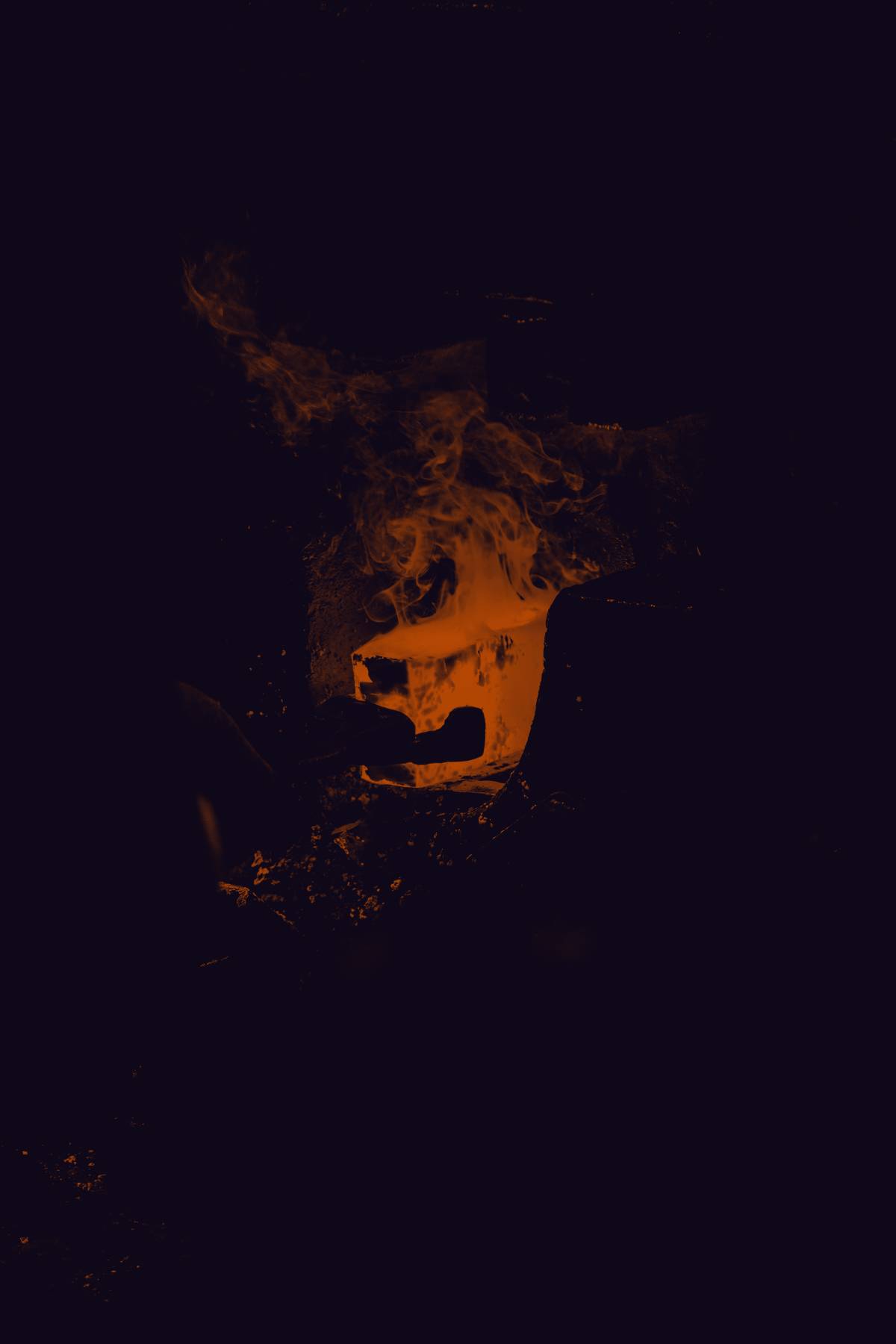 A blacksmith's forge, the metal in the fire glowing white-hot